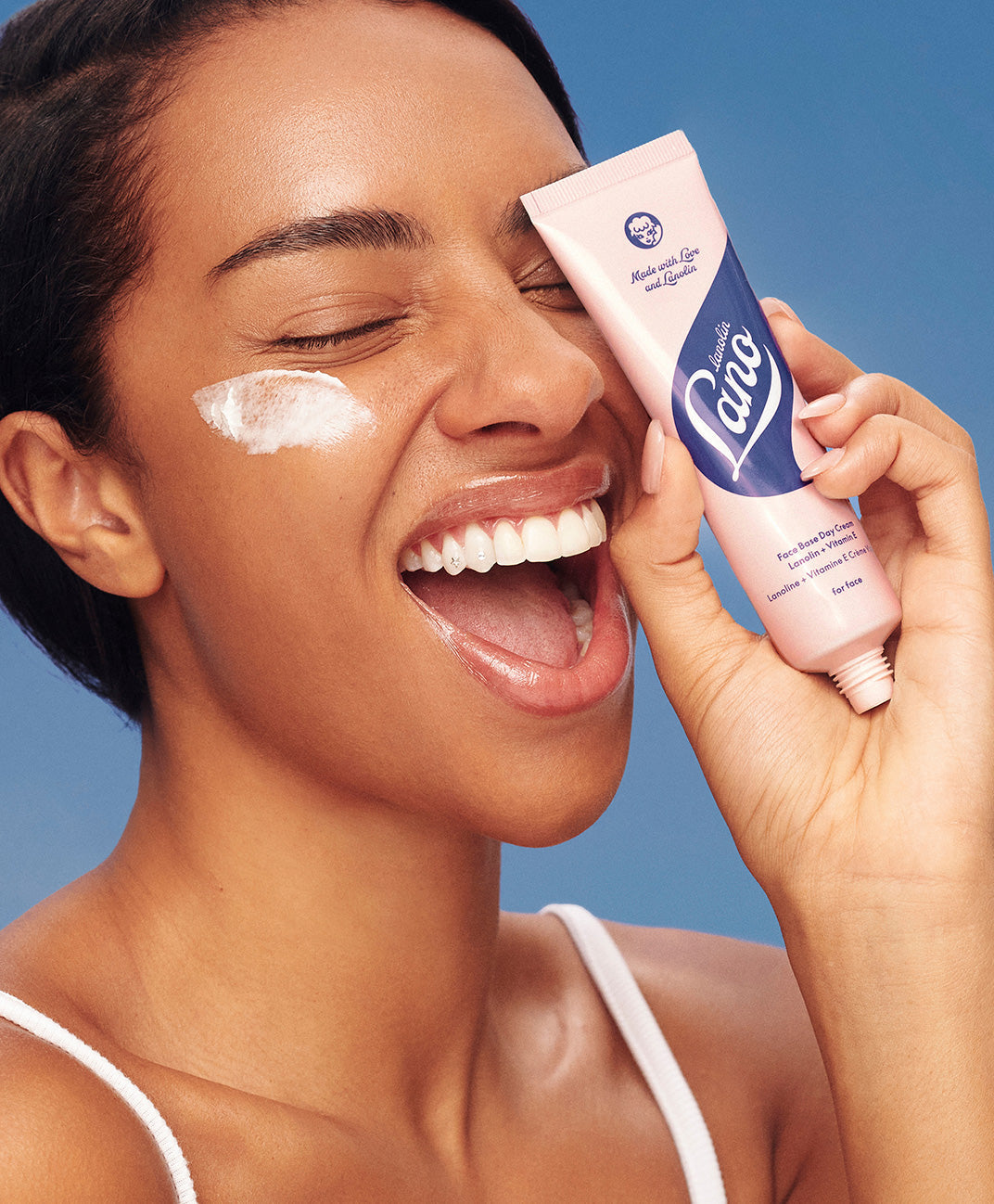 Model holding Lanolips Face Base Vitamin E Cream.