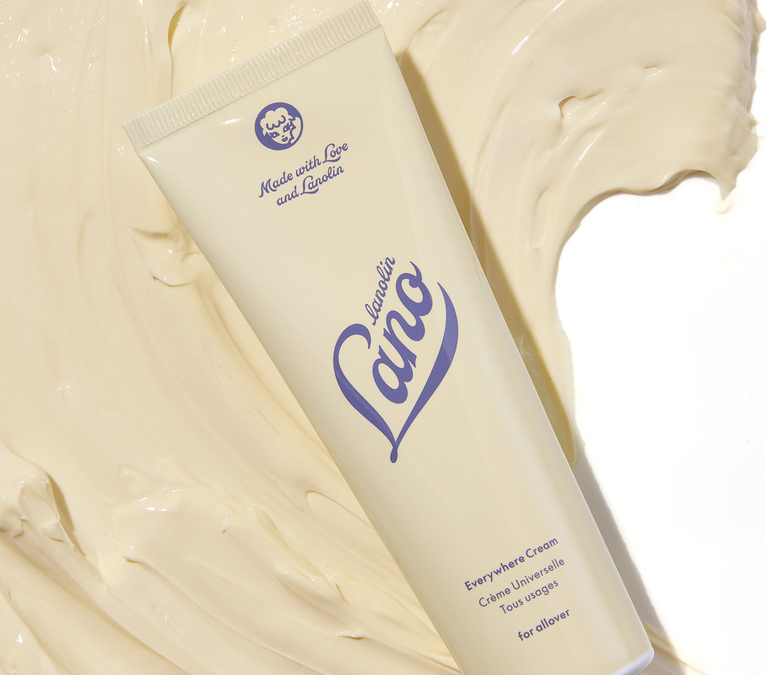 A tube of Lanolips Everywhere Cream sits on a rich, creamy texture, showcasing its ultra-hydrating formula. Infused with double lanolin, milk, and vitamin E, this all-in-one moisturiser deeply nourishes dry, thirsty skin. It transforms ashy, dehydrated skin into a soft, glowing complexion. A true multitasker, it replaces face cream, hand cream, body lotion, and even baby cream—perfect for all-over hydration, day or night.