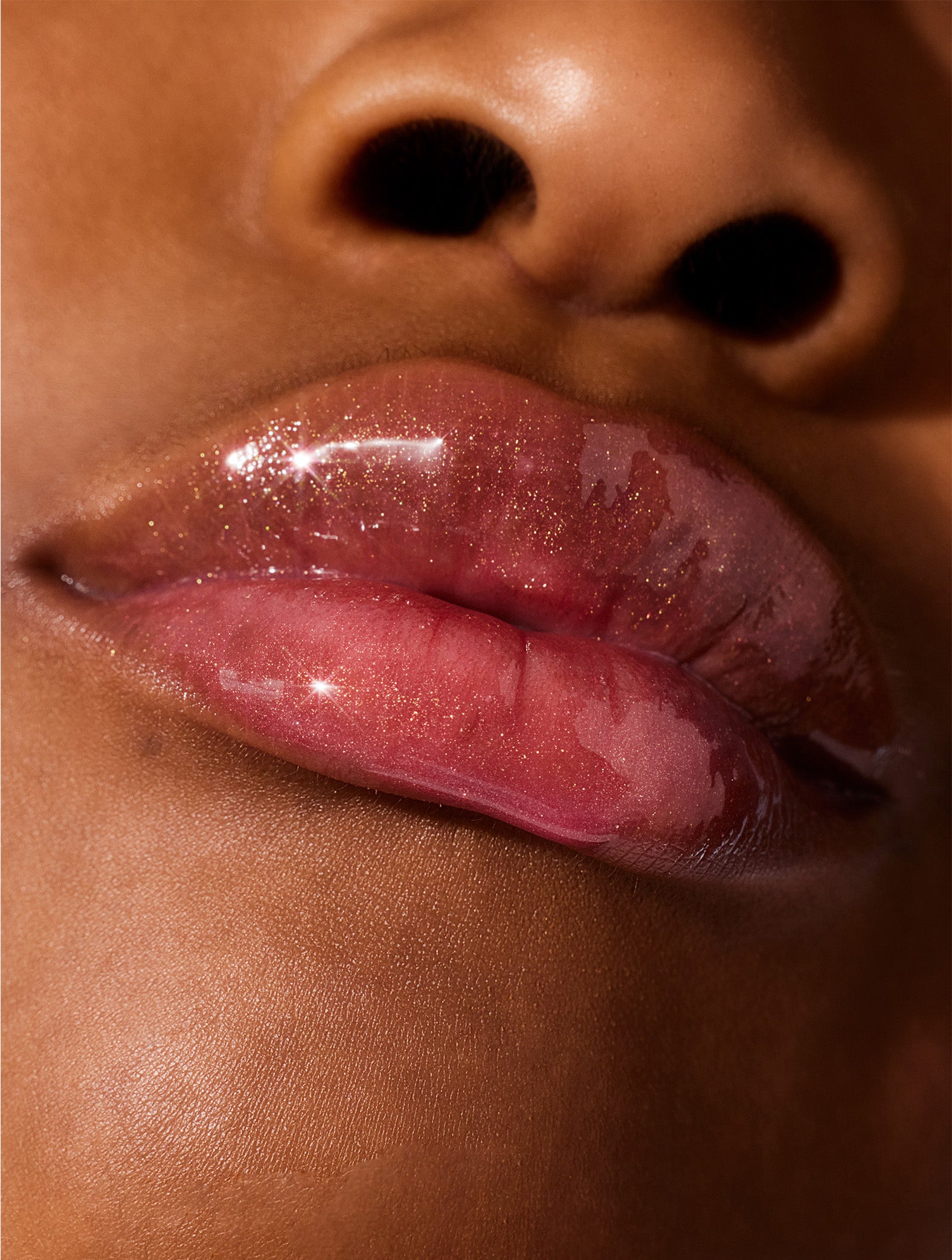 Close up shot of model wearing Lanolips Lip Water Watermelon. Made with liquid lanolin, hyaluronic acid, glycerin and natural flavours, delivering deep hydration with a refreshing, non-sticky finish. Like a serum but lighter, Lip Water feels like a cool drink of water for your lips – leaving them plump, soft, and glistening.