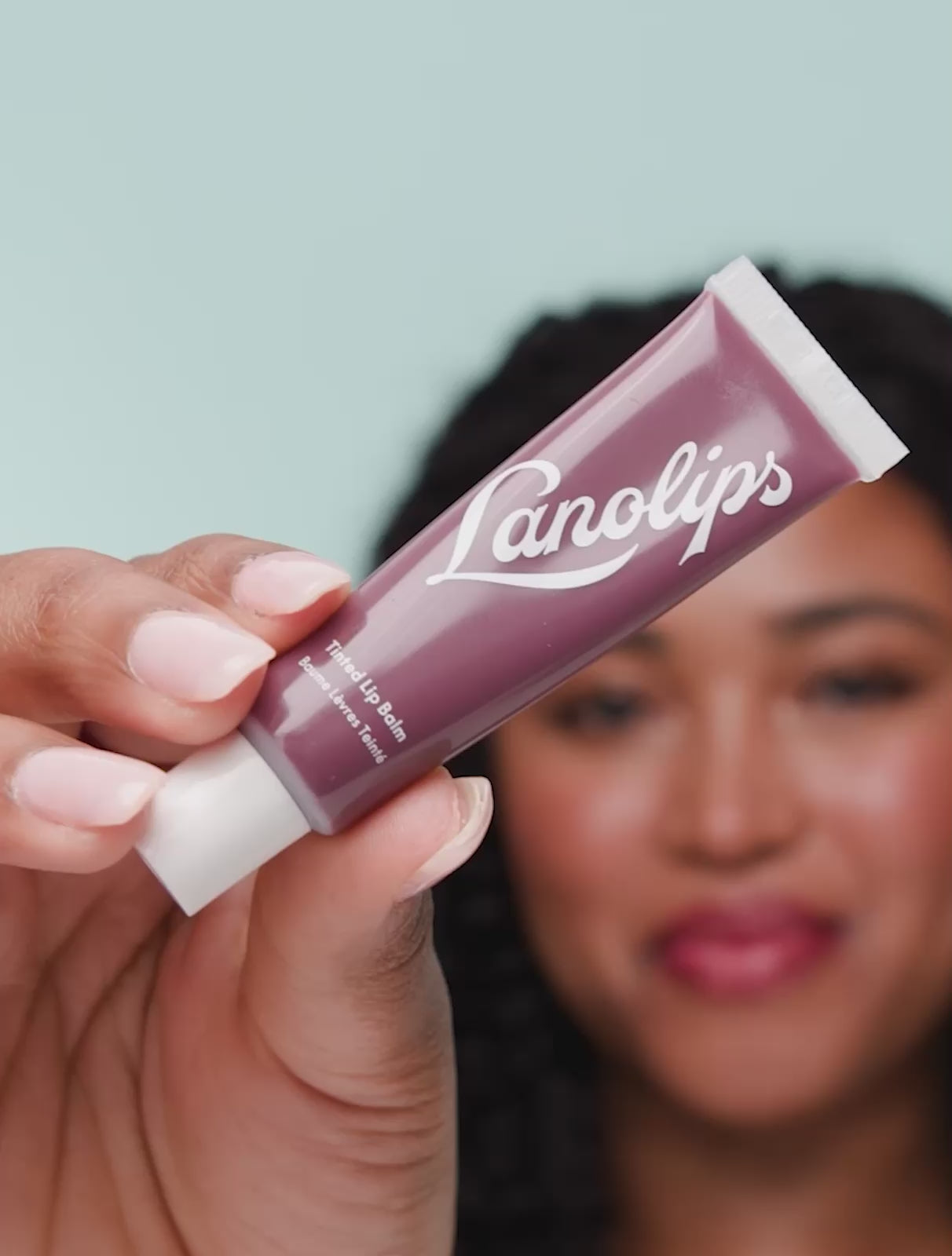Video of a model applying and wearing Lanolips Tinted Lip Balm in Spice, a sheer rich-plum shade inspired by the 90s. This hydrating balm gives a wine-stained lip look with none of the dryness. Enriched with all-natural lanolin for smooth, moisturised lips with a natural tint and healthy glow.