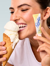 Load image into Gallery viewer, Model holding Lanolips 101 Ointment Multi Balm Vanilla and eating vanilla ice cream cone
