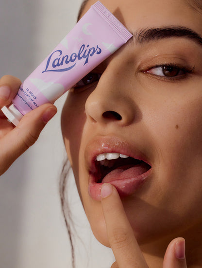 Model applying Lanolips 12 Hour Overnight Lip Mask, while cover the tube with one eye.