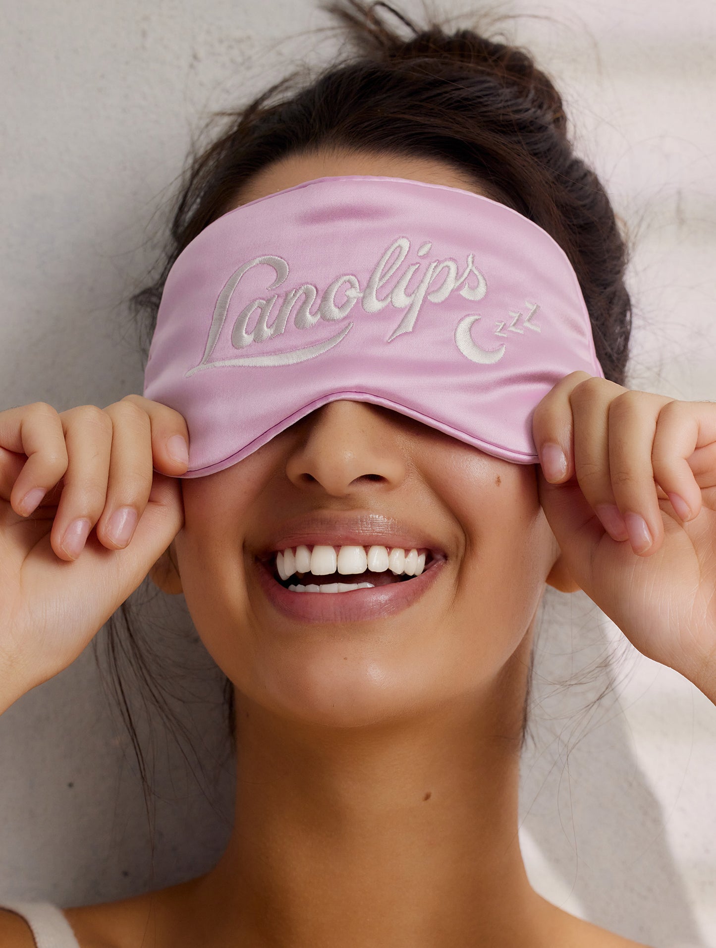 Model after using Lanolips 12 Hour Overnight Lip Mask, covering her eyes with an eye mask. 
