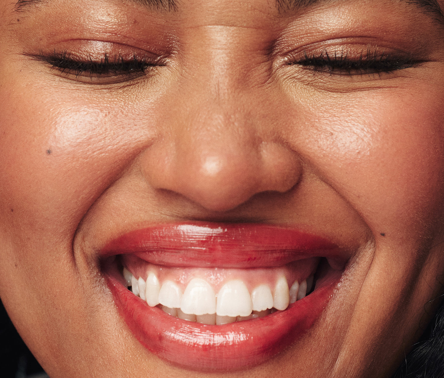 Close up shot of a woman wearing the Lanolips Tinted Lip Balm SPF 30 in REd Apple. Infused with lanolin, vitamin E, and shea butter, this cult-favourite balm provides deep, non-sticky hydration that lasts for hours. The high-gloss sheen enhances her natural lip shape, while SPF30 protection shields against sun damage. With a lightweight feel and just the right amount of pigment, this everyday essential adds a fresh, wearable tint that can be layered from subtle to bold. 