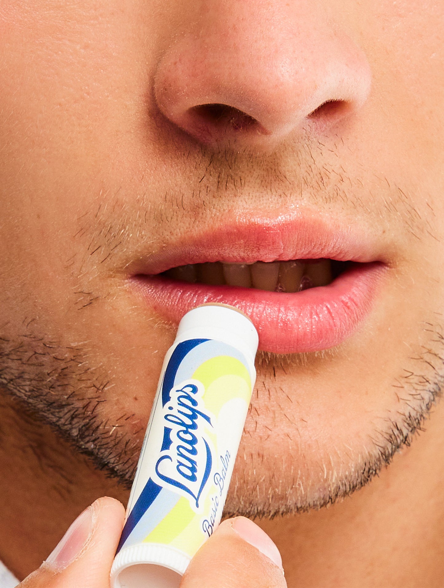 Model applying Lanolips Basic Balm Vanilla. It contains lanolin, vitamin-e, avocado oil and vanilla extract.