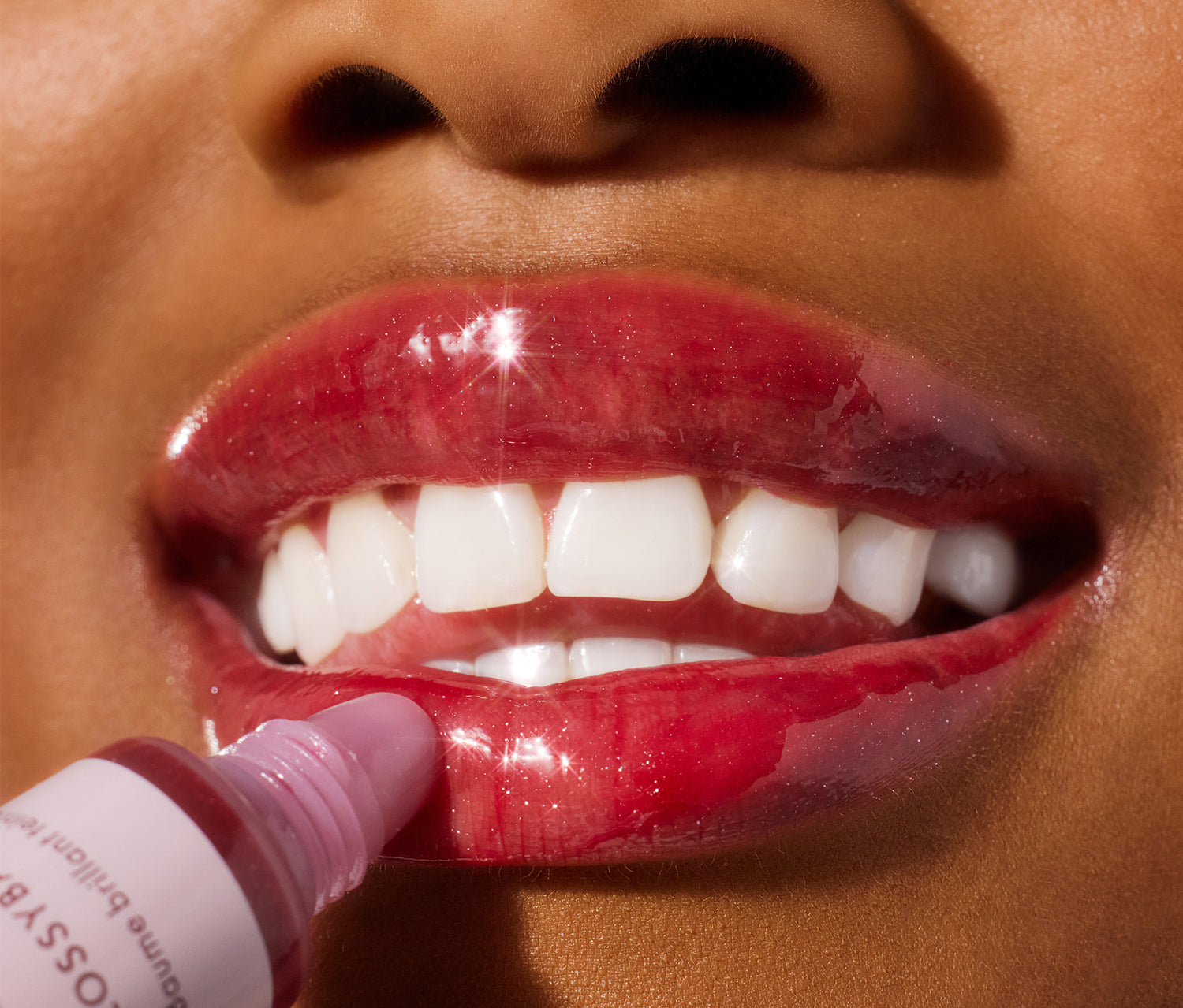 Model applying lanolips glossybalm berry on her lips.