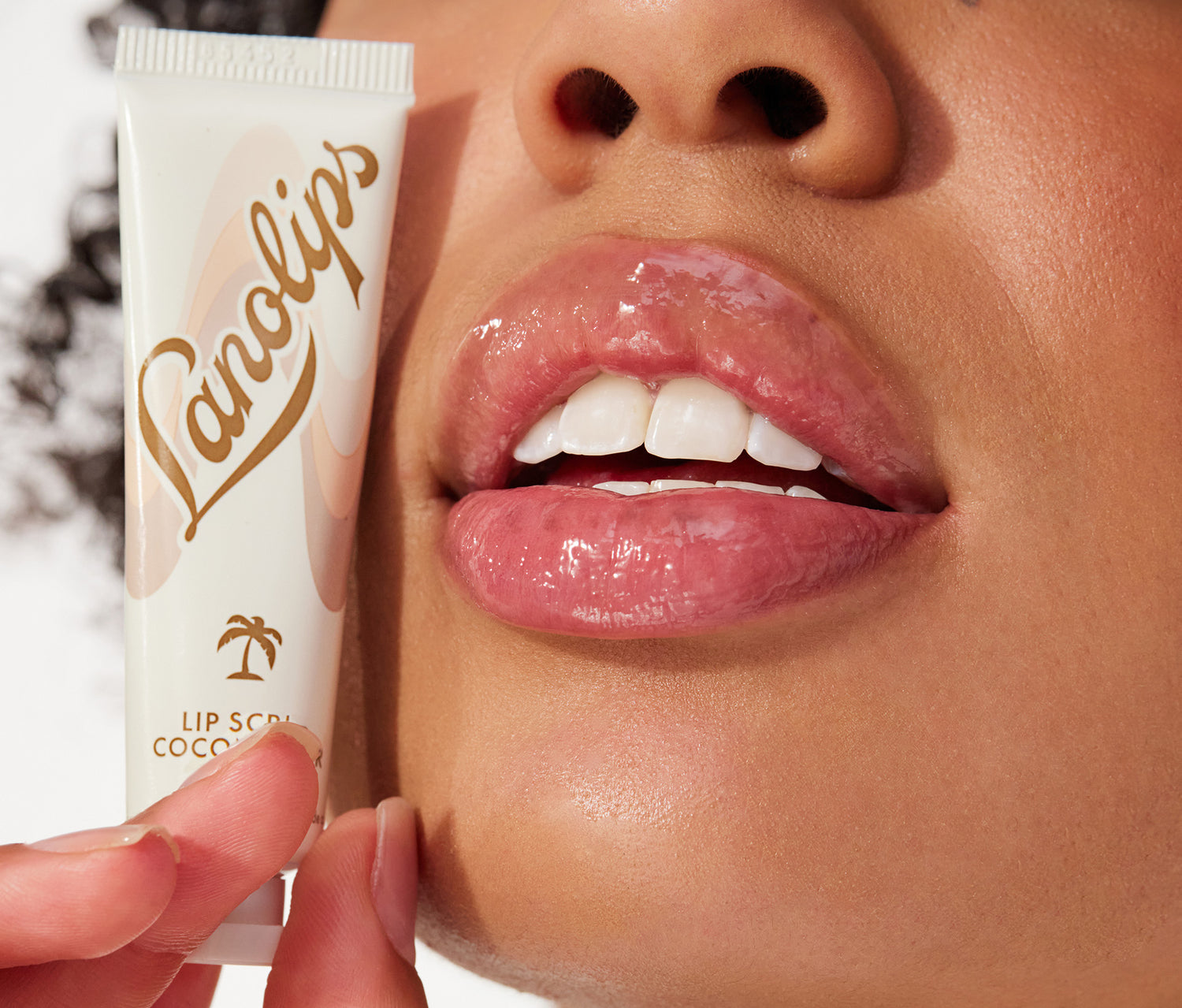 Model holding a lanolips lip scrub coconutter in her hand.