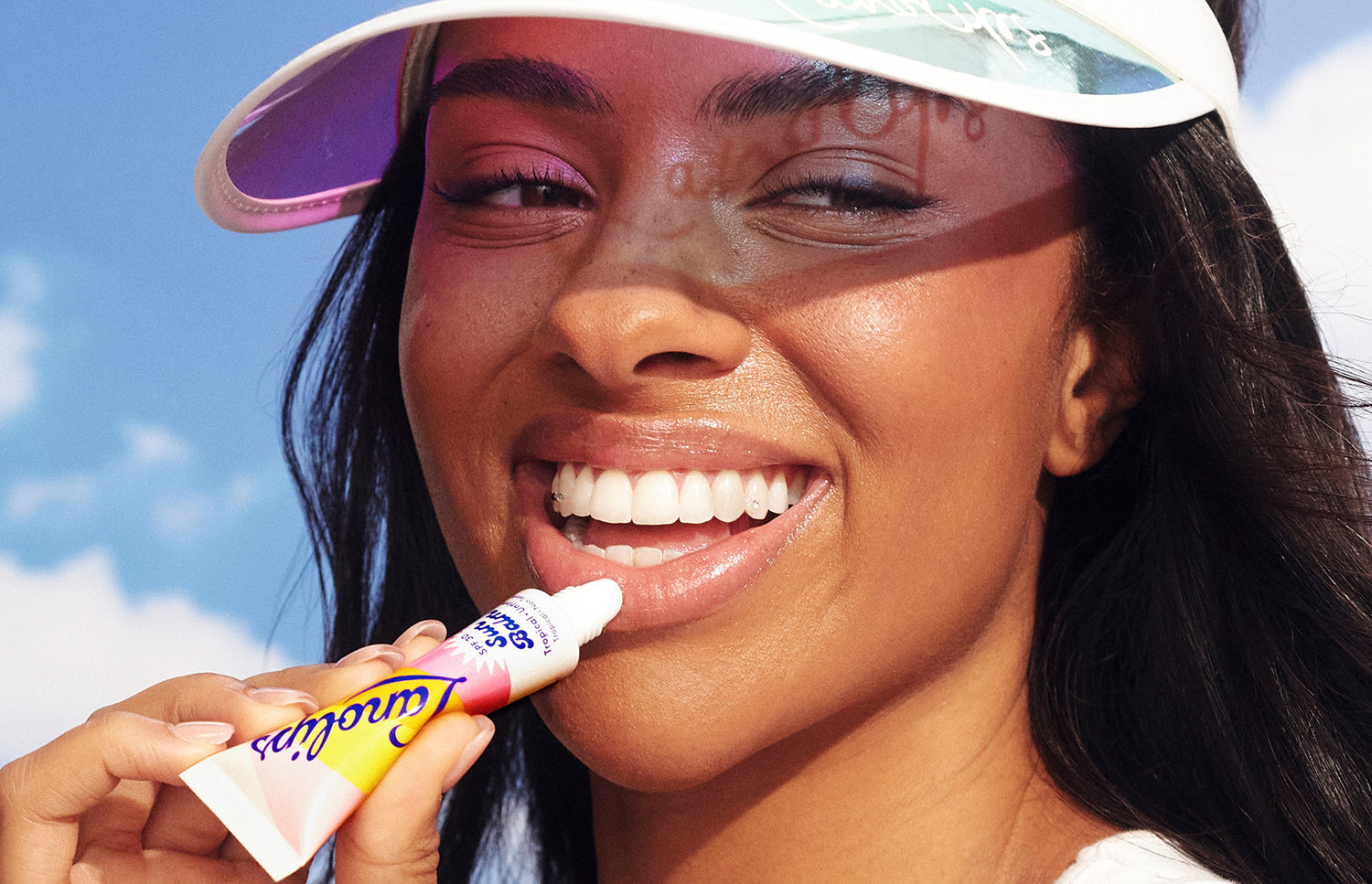 Model applying Sun Balm SPF 30 untinted lip balm on her lips. Made with hydrating lanolin, vitamin e, shea butter and SPF - it's a sun in a tube. 