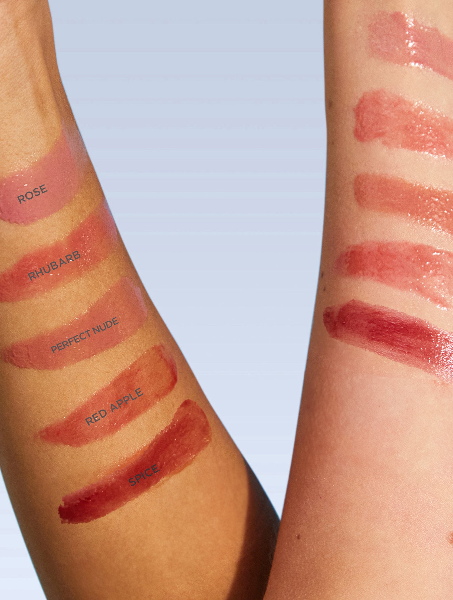 Swatches of Lanolips Tinted Lip Balm  SPF30 range in shades Rose, Rhubarb, Perfect Nude, Red Apple and Spice are spread across a white background, showcasing their sheer, glossy finish. This lanolin-rich lip moisturiser provides deep hydration while delivering a sheer colour tint for a natural, healthy glow.  The lightweight, non-sticky formula enhances lips with a dewy, tinted shine, making it the perfect everyday essential.