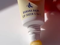 Load and play video in Gallery viewer, Video of Lanolips Banana Balm Lip Sheen 3-in-1 being squeezed from the tube
