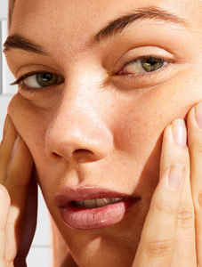 Model applying Face Base Vitamin-E Day Cream onto face.